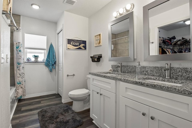 full bathroom with visible vents, a sink, wood finished floors, and toilet