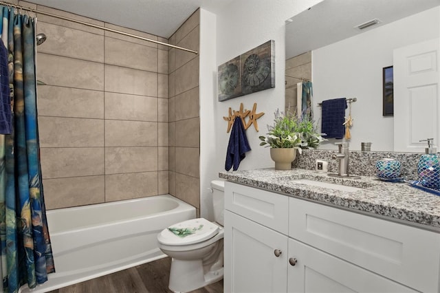 bathroom featuring vanity, toilet, shower / bathtub combination with curtain, wood finished floors, and visible vents