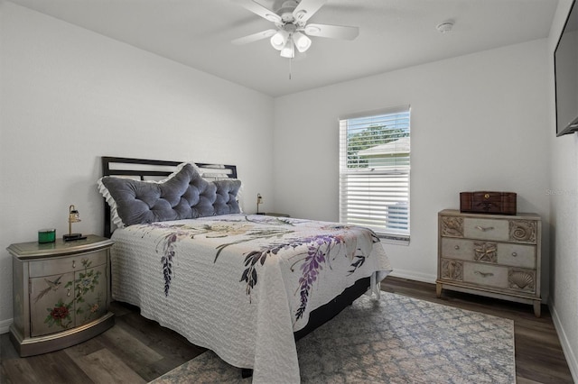 bedroom featuring baseboards, a ceiling fan, and dark wood-style floors