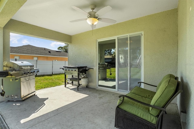 view of patio with fence, a ceiling fan, and a grill