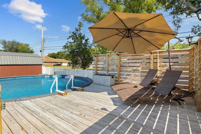 view of swimming pool featuring a deck, a fenced in pool, and fence