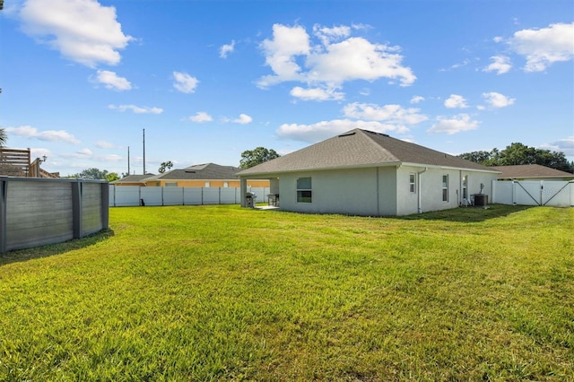 view of yard featuring a fenced backyard and central AC