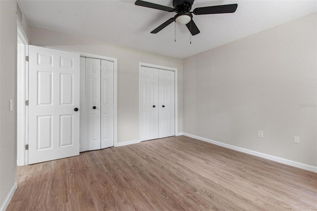6317 Discovery Ln, Land O Lakes, FL 34638 - unfurnished bedroom featuring baseboards, two closets, visible vents, and wood finished floors