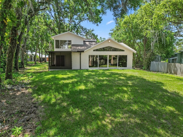 6317 Discovery Ln, Land O Lakes, FL 34638 - rear view of property featuring stucco siding, fence, a yard, and a sunroom