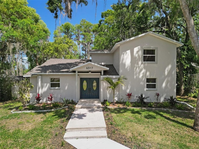 6317 Discovery Ln, Land O Lakes, FL 34638 - view of front facade with stucco siding, roof with shingles, and a front lawn