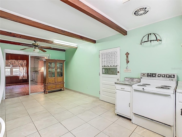 kitchen with white range with electric cooktop, light countertops, light tile patterned floors, white cabinets, and beamed ceiling