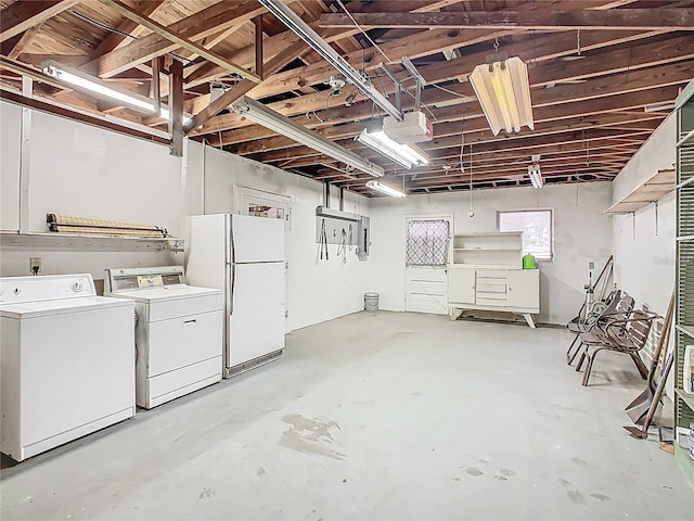 below grade area featuring freestanding refrigerator and washing machine and clothes dryer