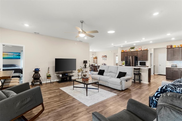 living area with recessed lighting, ceiling fan, visible vents, and light wood-style floors