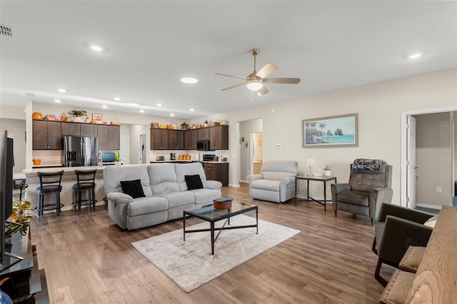 living room with visible vents, recessed lighting, ceiling fan, and wood finished floors