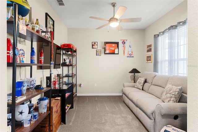 living room featuring ceiling fan, visible vents, baseboards, and carpet