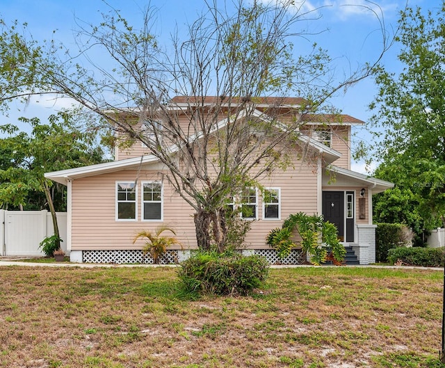 view of front of property featuring a front lawn and fence