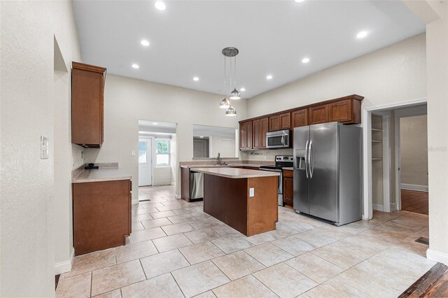 kitchen featuring appliances with stainless steel finishes, a sink, light countertops, a center island, and recessed lighting