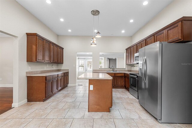 kitchen featuring hanging light fixtures, a sink, light countertops, stainless steel appliances, and recessed lighting