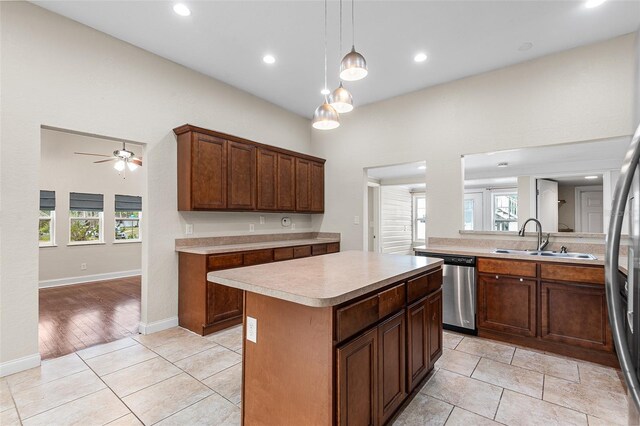 kitchen with a kitchen island, ceiling fan, light countertops, a sink, and dishwasher