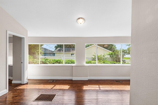 interior space with visible vents, a wealth of natural light, and hardwood / wood-style floors