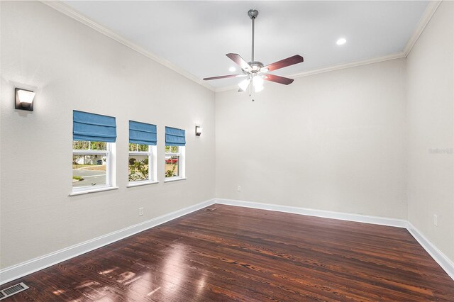 empty room with visible vents, ornamental molding, ceiling fan, and wood finished floors