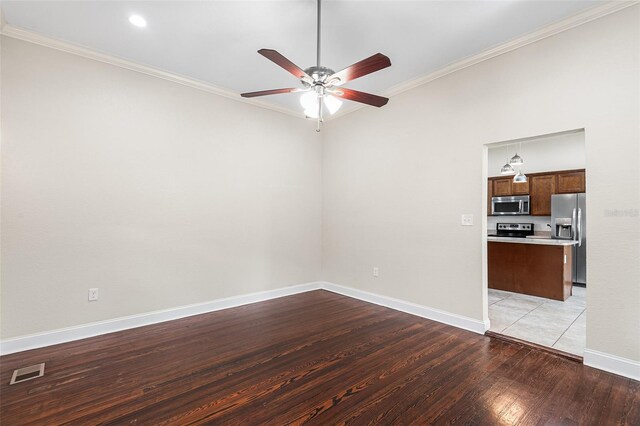 spare room with visible vents, crown molding, baseboards, light wood-type flooring, and a ceiling fan