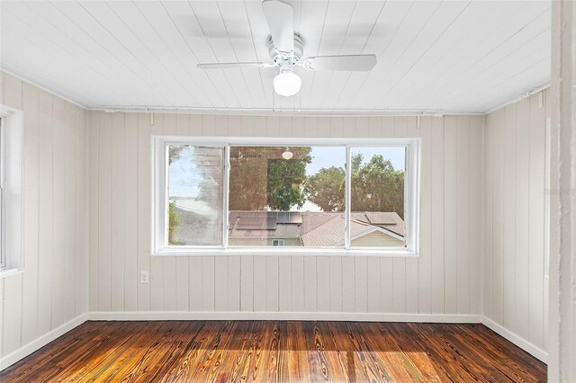 spare room with dark wood-style flooring, baseboards, and a ceiling fan