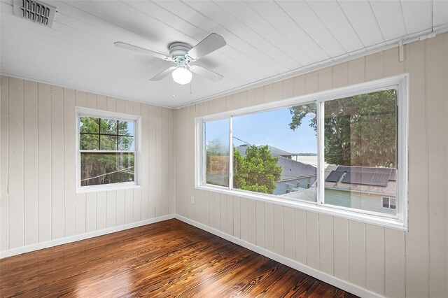 empty room featuring baseboards, a ceiling fan, hardwood / wood-style flooring, and visible vents