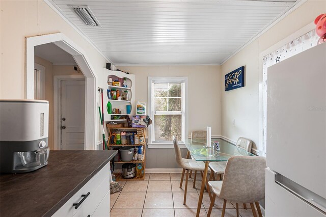 dining room with visible vents, ornamental molding, baseboards, and light tile patterned flooring