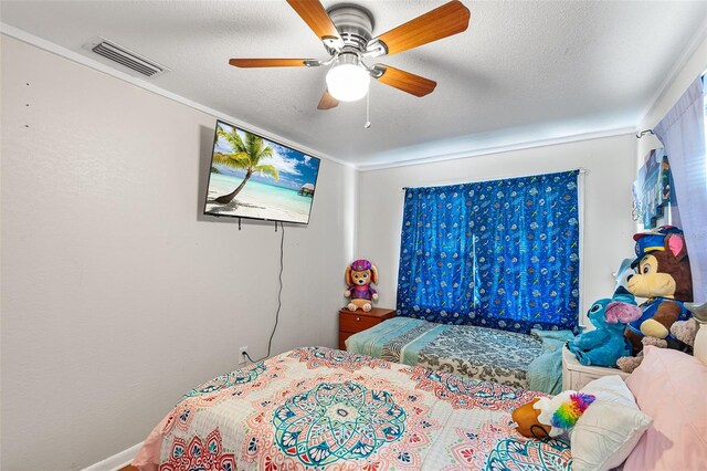 bedroom with a textured ceiling, ceiling fan, visible vents, and ornamental molding