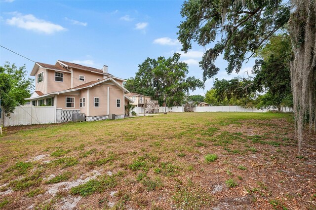 view of yard featuring central AC unit and a fenced backyard