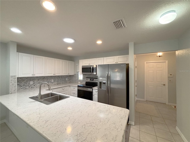 4480 Turnberry Ln, Lake Wales, FL 33859 - kitchen with visible vents, a sink, baseboards, a peninsula, and stainless steel appliances