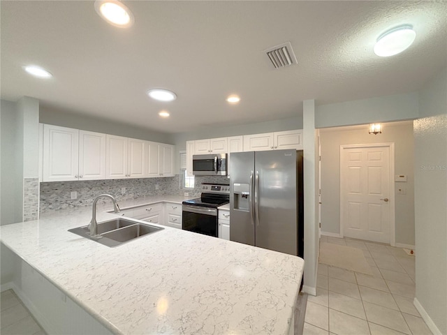 4480 Turnberry Ln, Lake Wales, FL 33859 - kitchen with visible vents, a sink, a peninsula, stainless steel appliances, and white cabinetry