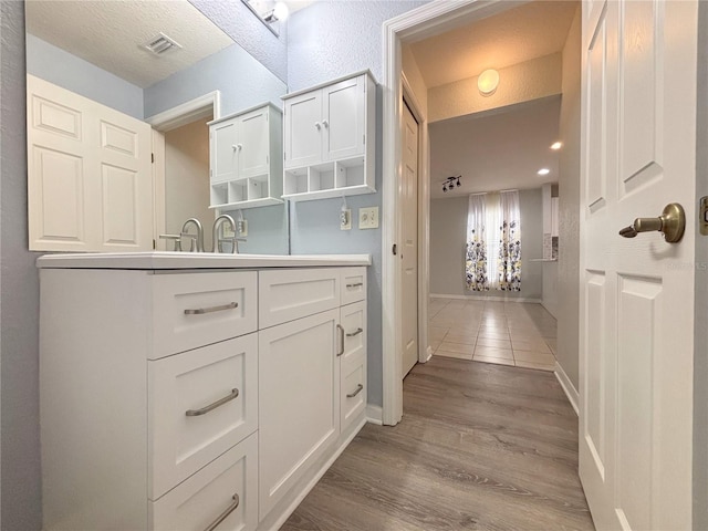 4480 Turnberry Ln, Lake Wales, FL 33859 - bathroom with visible vents, baseboards, wood finished floors, and vanity