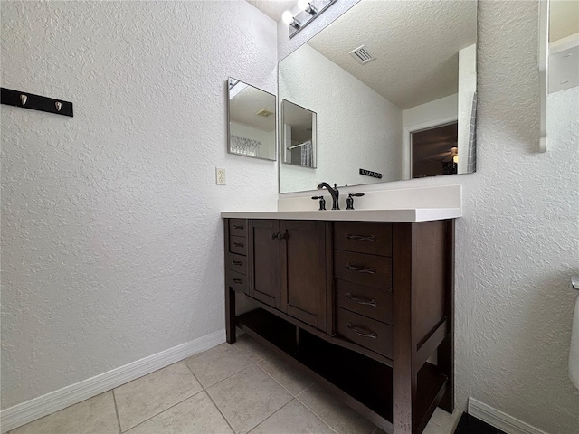4480 Turnberry Ln, Lake Wales, FL 33859 - bathroom with visible vents, vanity, baseboards, a textured ceiling, and tile patterned floors