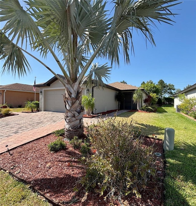 4480 Turnberry Ln, Lake Wales, FL 33859 - single story home featuring an attached garage, a front lawn, stucco siding, and decorative driveway