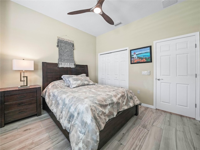 bedroom featuring light wood-style floors, visible vents, and a closet