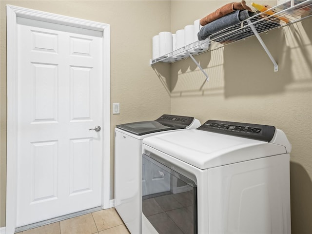 laundry area with laundry area, light tile patterned floors, and washing machine and dryer