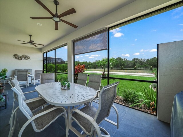 sunroom featuring a ceiling fan and outdoor dining area
