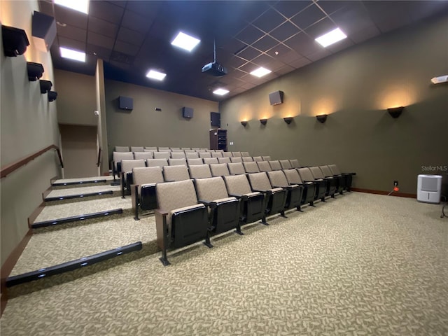 cinema room with carpet flooring, baseboards, and a paneled ceiling