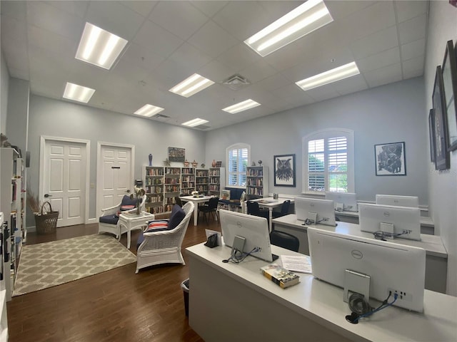 office area with visible vents, dark wood finished floors, and a paneled ceiling