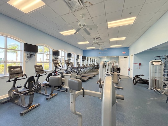 exercise room with a ceiling fan and a paneled ceiling