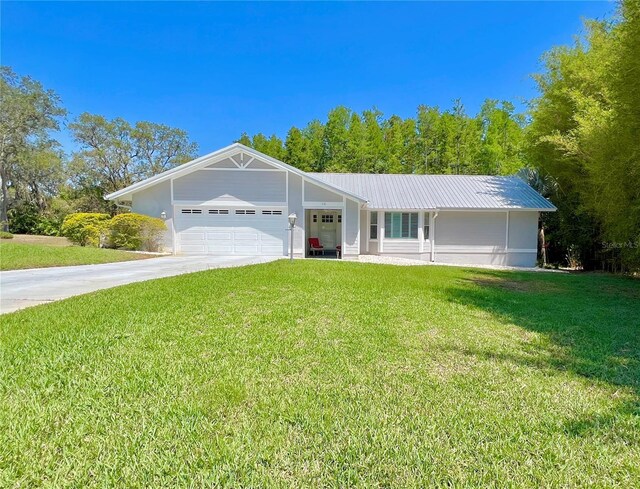 ranch-style house featuring a garage, driveway, and a front lawn