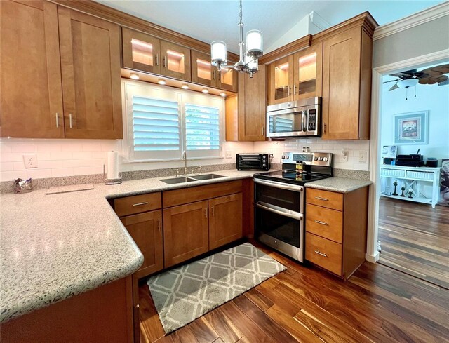 kitchen featuring a sink, stainless steel appliances, brown cabinets, and dark wood-style floors
