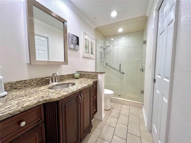 bathroom with crown molding, a shower stall, vanity, toilet, and a textured wall