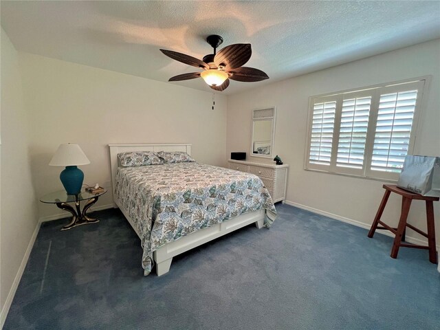 bedroom featuring baseboards, ceiling fan, dark carpet, and a textured ceiling