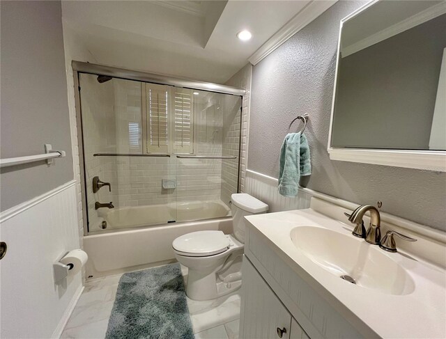 full bathroom featuring shower / bath combination with glass door, marble finish floor, a wainscoted wall, and toilet