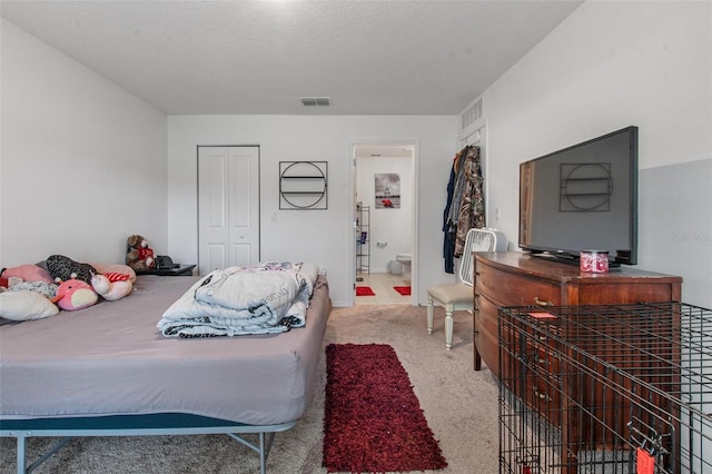 carpeted bedroom with visible vents and a closet