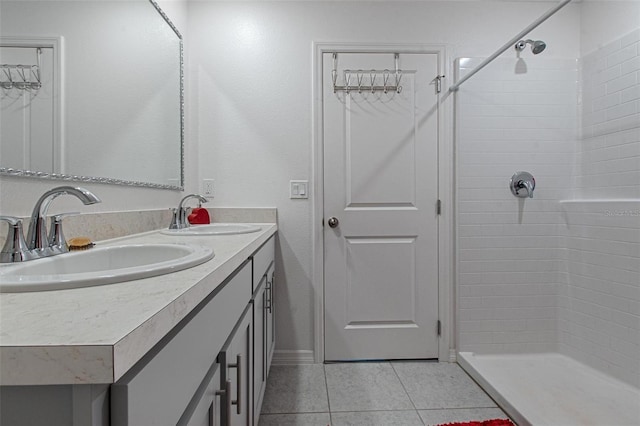 full bathroom featuring a sink, tile patterned floors, and a tile shower
