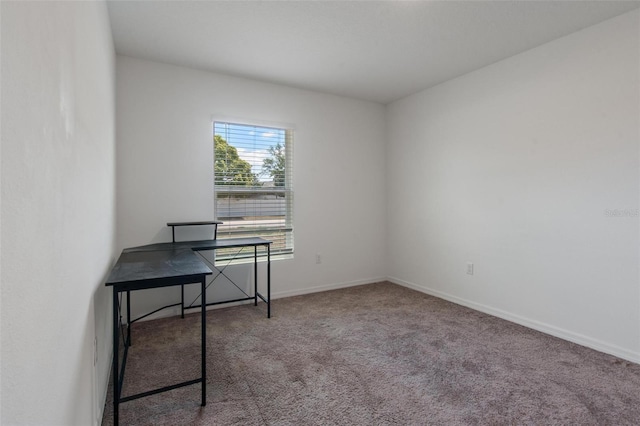 unfurnished office featuring baseboards and carpet
