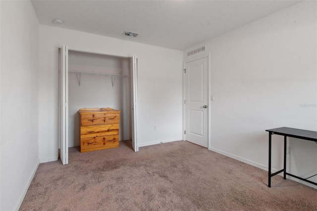 unfurnished bedroom with carpet floors, baseboards, visible vents, and a closet