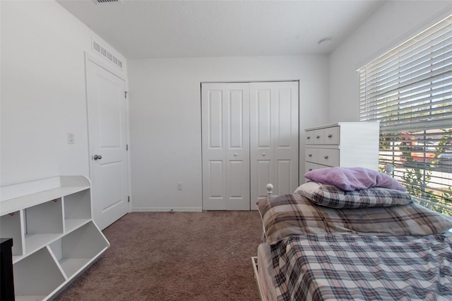 carpeted bedroom featuring visible vents, baseboards, and a closet