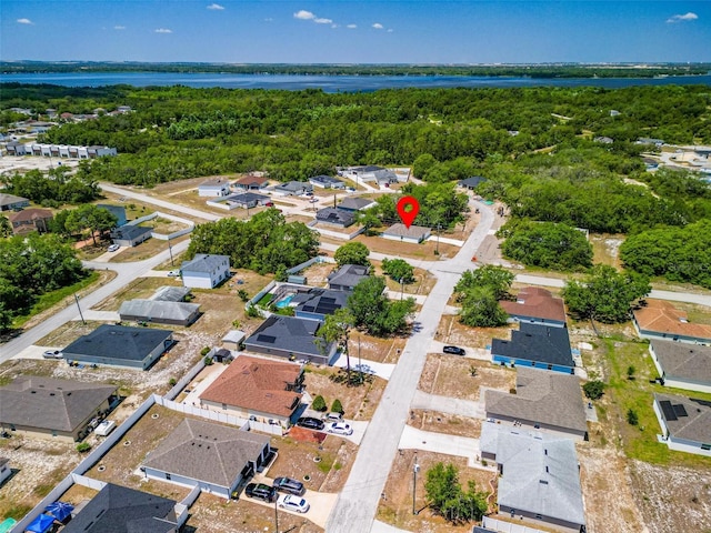 birds eye view of property featuring a water view, a residential view, and a forest view