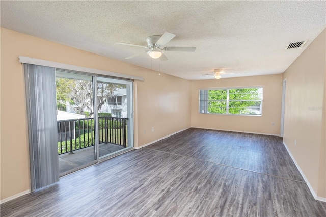 spare room with a textured ceiling, ceiling fan, visible vents, and wood finished floors