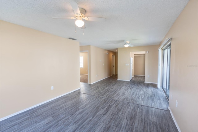 unfurnished living room featuring ceiling fan, dark wood-style flooring, a textured ceiling, visible vents, and baseboards